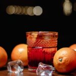 orange fruit beside clear drinking glass